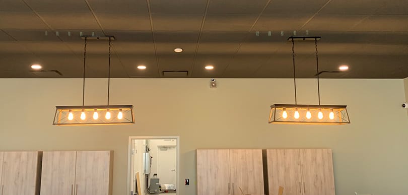 Hanging light installation above store front desk