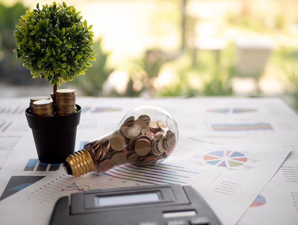 financial statements with a lightbulb filled with change coins